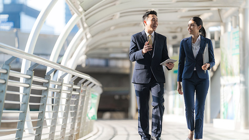 man and women in suit walking and chatting